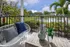 Charming patio retreat with cozy seating, lush garden views, and serene water feature.