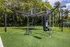 Outdoor fitness area with a durable punching bag, versatile ropes, and training equipment set against lush greenery.