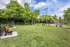 Charming community park featuring lush greenery, inviting benches, and a cozy gazebo under a vibrant blue sky.