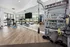 Contemporary fitness center featuring cardio bikes, TRX equipment, and a sleek mirrored wall in a bright, airy space.