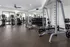 Contemporary fitness center with state-of-the-art equipment, featuring treadmills, weight machines, and free weights in a bright, spacious setting.