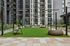 Modern apartment courtyard with sleek outdoor seating, inviting green lawn, and stylish urban architecture.