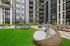 Modern apartment courtyard with inviting lounge seating, lush green lawn, and cozy hammock for relaxation.