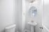 unfurnished half bathroom with toilet, sink and mirror in home