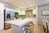 Modern kitchen with sleek stainless steel appliances, elegant marble countertops, and stylish bar seating.