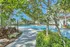 Tropical paradise with a luxurious pool surrounded by lush greenery and palm trees, offering a serene escape.