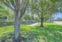 Charming community park with lush green grass, mature trees, and inviting seating areas, perfect for relaxation and enjoyment.