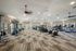 Spacious and modern gym with state-of-the-art exercise equipment, including stationary bikes, elliptical machines, and resistance stations, offering a vibrant workout environment.