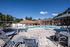 Main community swimming pool with lounge seating, shaded cabanas, and surrounding clubhouse buildings on a sunny day.