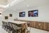 Spacious resident lounge with high ceilings, modern seating areas, a bar-style counter, and natural light from large windows.