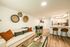 Modern apartment home interior featuring an open living area, contemporary furnishings, decorative wall accents, and a kitchen with a breakfast bar.