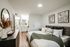 Primary bedroom with modern furnishings, layered bedding, neutral decor, and an en-suite bathroom vanity.