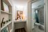 Built-in desk nook with shelving and workspace adjacent to a bathroom with modern fixtures and a shower-tub combination.