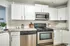 Modern kitchen with sleek stainless steel appliances, granite countertops, and white cabinets, designed for style and functionality.