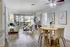 Modern living room with stylish decor, a cozy sofa adorned with vibrant cushions, an elegant wooden coffee table, and a welcoming dining area with contemporary dining chairs.