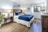 Elegant bedroom with plush carpeting, modern decor, and cozy natural lighting.