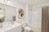 Modern bathroom featuring elegant fixtures, a sleek white countertop, and artistic wall decor for a sophisticated touch.