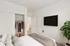Cozy bedroom with a modern gray sofa accented by vibrant throw pillows, an elegant floor lamp, and stylish decor elements.