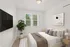 Cozy bedroom with a modern gray sofa accented by vibrant throw pillows, an elegant floor lamp, and stylish decor elements.