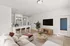 Cozy living room with a modern gray sofa accented by vibrant throw pillows, an elegant floor lamp, and stylish decor elements.