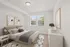 Cozy bedroom with a modern gray sofa accented by vibrant throw pillows, an elegant floor lamp, and stylish decor elements.