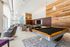 Stylish lounge with a pool table, TV, armchairs, and wood accent walls.