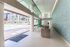 Indoor-outdoor lounge with a bar, modern lighting, textured glass wall, and view of the pool and garden planters.