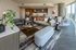 Stylish apartment interior featuring a spacious living area, modern kitchen with bar seating, and large windows offering natural light and city views.