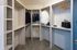 Spacious walk-in closet with built-in shelving, ample hanging space, and a small dresser under a window.