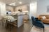 Open kitchen with bar seating and view of a cozy lounge with velvet and leather seating.