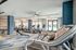 Spacious apartment fitness center with treadmills, ellipticals, stationary bikes, a rowing machine, and large windows allowing natural light into the room.