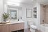 Modern bathroom with light wood vanity, large mirror, open shelving, a shower-tub combo with tiled walls, and minimalistic decor for a clean and stylish look.