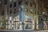 Nighttime view of The Grant apartment entrance, illuminated with exterior lighting and festive string lights wrapped around a tree, creating a welcoming and upscale atmosphere.