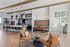 Stylish resident lounge featuring a long communal table, leather booth seating, modern pendant lighting, and wall art.
