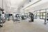 Spacious modern fitness center featuring cardio equipment, weight machines, free weights, and floor-to-ceiling windows.