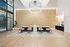 Elegant leasing office with a modern chandelier, wood-accented feature wall, patterned tile flooring, and a sleek front desk with guest seating