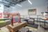 Bright game lounge with a foosball table, bike rack, casual seating, large windows, and industrial-style lighting with exposed ceilings.