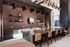 Sleek community bar lounge with modern lighting, bar seating, open shelving, and a warm, inviting ambiance.