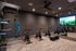 Indoor fitness studio with spin bikes, weights, suspension straps, and a virtual workout screen.