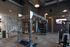 Spacious fitness center with strength training equipment including squat racks, benches, and cable machines.