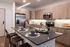Open-concept kitchen with light wood cabinetry, stainless steel appliances, a large island, and place settings for dining.
