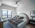 Modern bedroom with large window, neutral tones, and cityscape view.