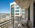 Modern apartment balcony with seating and a city skyline view.