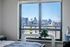 Large window with a clear view of the city skyline from a modern apartment.
