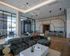 Expansive lounge area featuring an open-concept kitchen, high ceilings, modern lighting, and floor-to-ceiling windows.