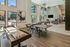 Spacious indoor clubroom with large windows, game tables, modern furnishings, and a wall-mounted TV, designed for relaxation and socializing.