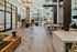 Modern indoor lounge area featuring work tables, cozy seating, and natural lighting, designed for both productivity and relaxation.