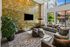 Stylish indoor lounge area with large windows, contemporary furniture, a wall-mounted TV, and a stone accent wall, filled with natural sunlight.