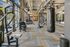 Well-equipped fitness center with strength training machines, punching bags, and free weight areas in a spacious, industrial-style interior.