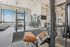 Luxury fitness center featuring premium cardio and strength training equipment, sleek modern design, and expansive floor-to-ceiling windows with panoramic skyline views.